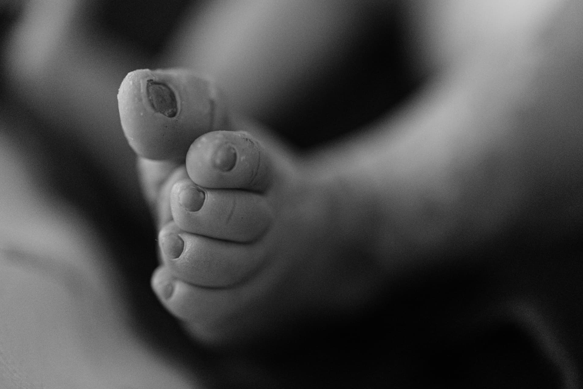 Detalhe dos pés do recém-nascido em fotografia documental
