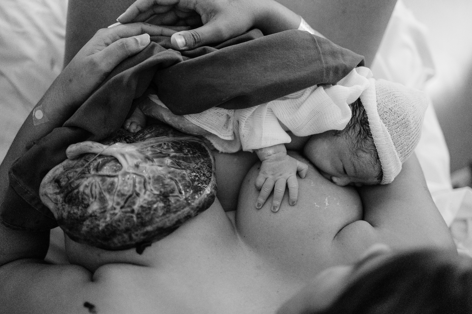 Bebê no colo da mãe momentos após o nascimento