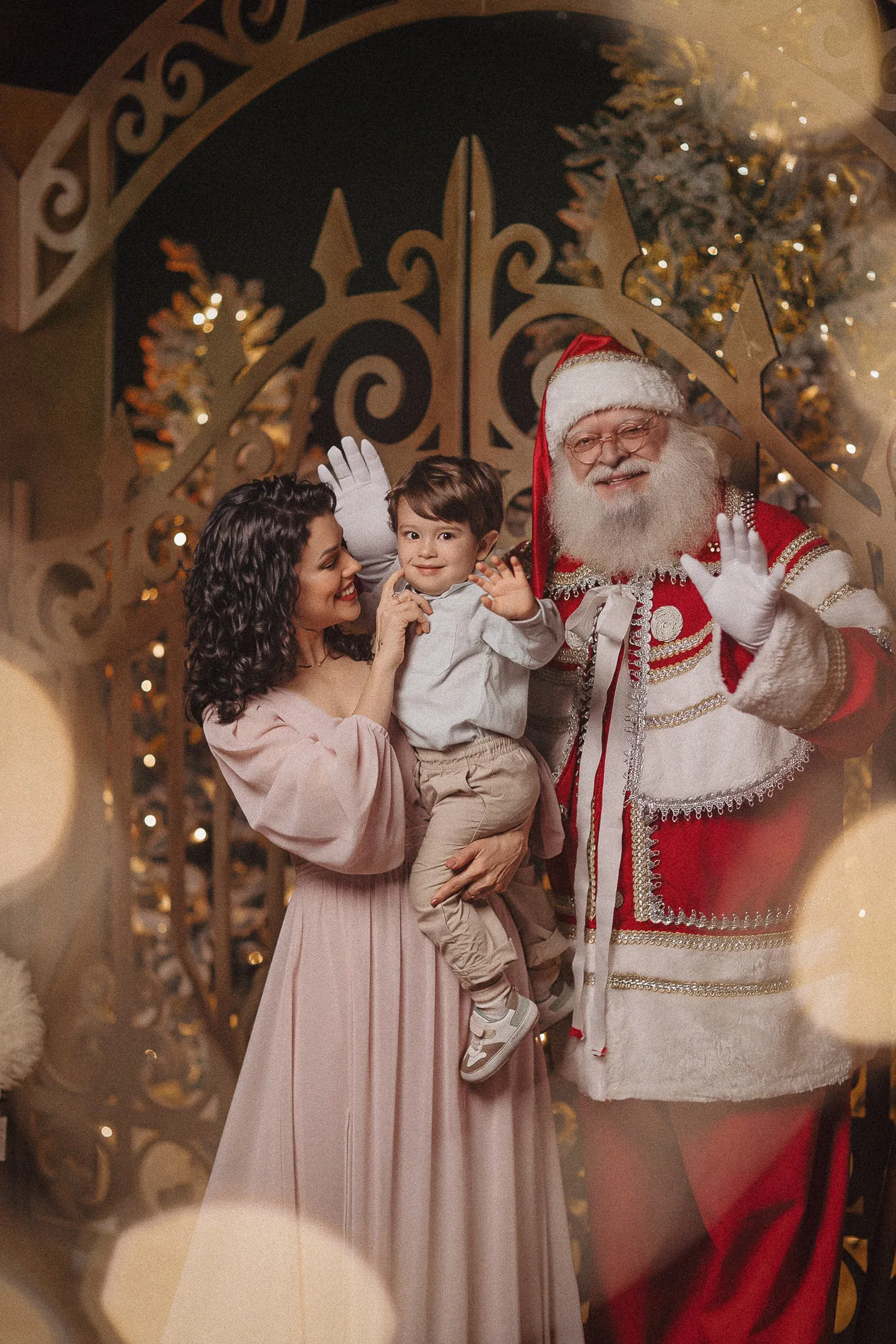 Mulher com a criança no colo ao lado de Papai Noel e do quebra-nozes.